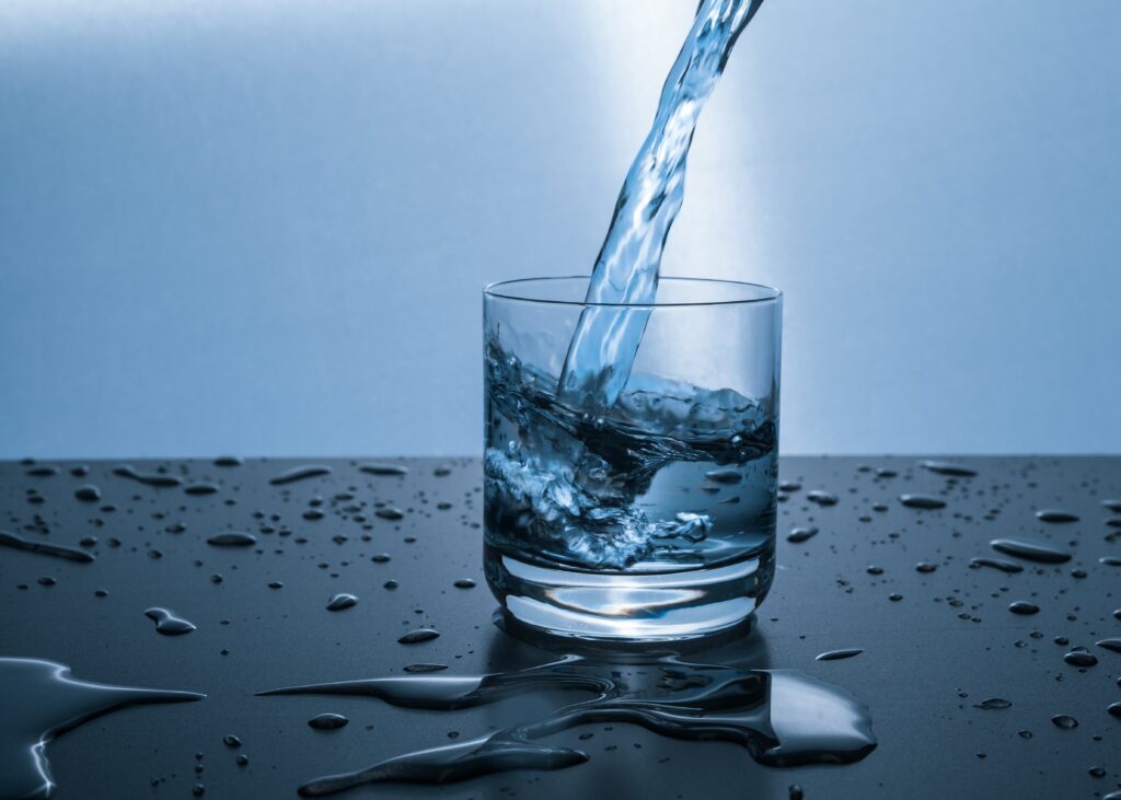 Water spilling into a glass on a wet counter