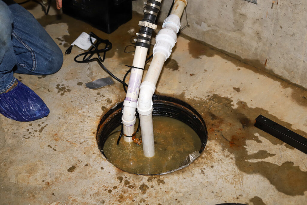 A plumber repairing a sump pump in a flooded basement in a residential home